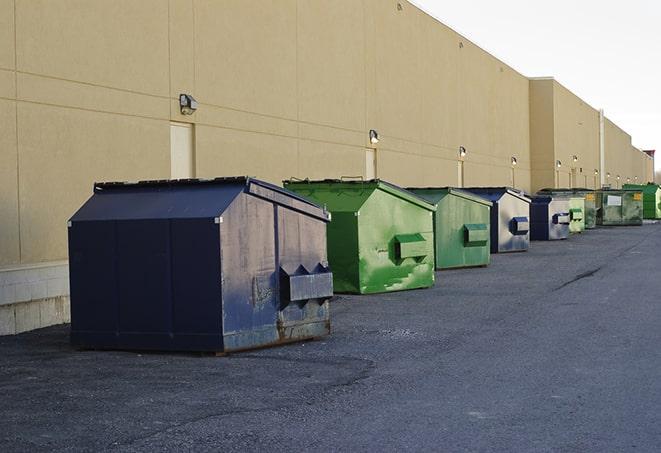 a collection of bright and vibrant dumpsters in a construction zone in Adelanto CA